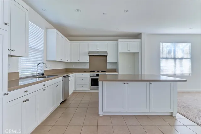 a kitchen with cabinets appliances a sink and a window
