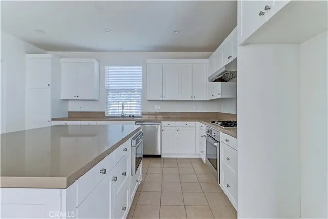 a kitchen with granite countertop a sink stove and cabinets