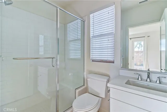 a bathroom with a toilet sink vanity and mirror
