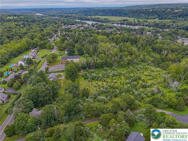an aerial view of a house with a yard and a large tree