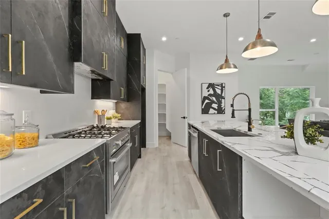 a kitchen with stainless steel appliances granite countertop a sink stove and cabinets