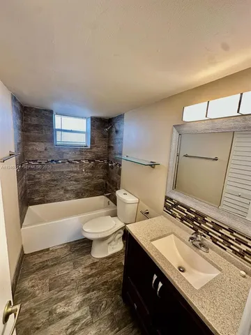 a bathroom with a sink toilet a mirror and bathtub