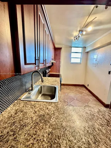 a kitchen with granite countertop a sink and a stove