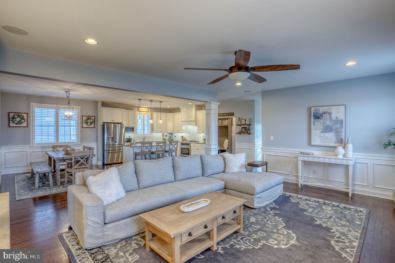 a living room with furniture a ceiling fan and a rug