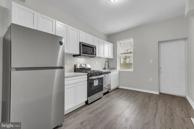 a kitchen with a refrigerator stove and wooden cabinets