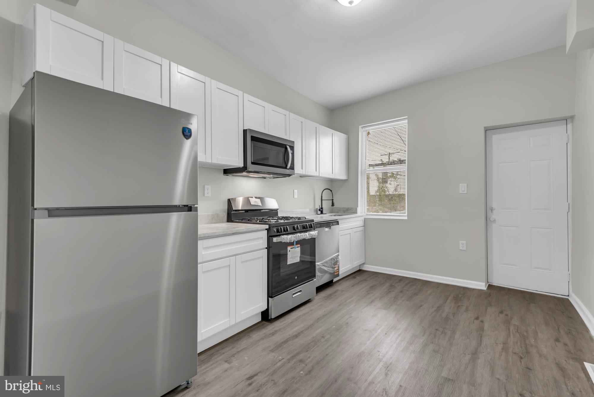 1904 Kennedy Avenue Baltimore, MD 21218 - Photo 11 of 29 a kitchen with a refrigerator stove and wooden cabinets