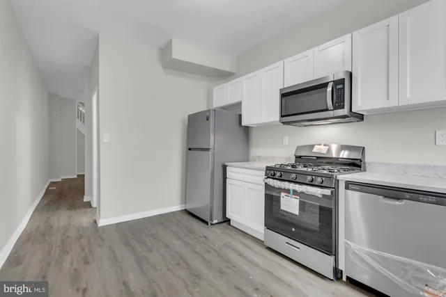 a kitchen with stainless steel appliances granite countertop a stove a microwave and a refrigerator