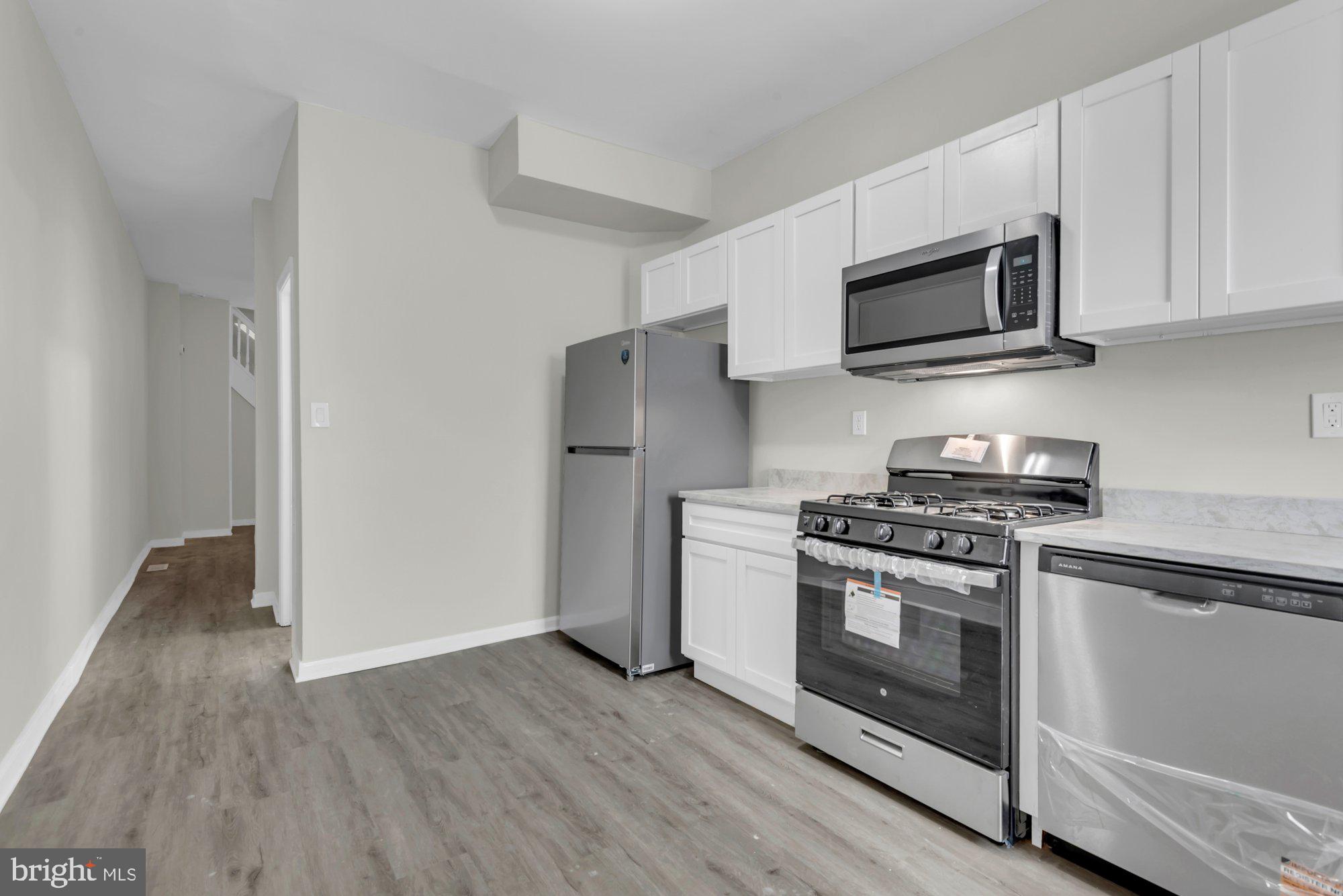 1904 Kennedy Avenue Baltimore, MD 21218 - Photo 14 of 29 a kitchen with stainless steel appliances granite countertop a stove a microwave and a refrigerator