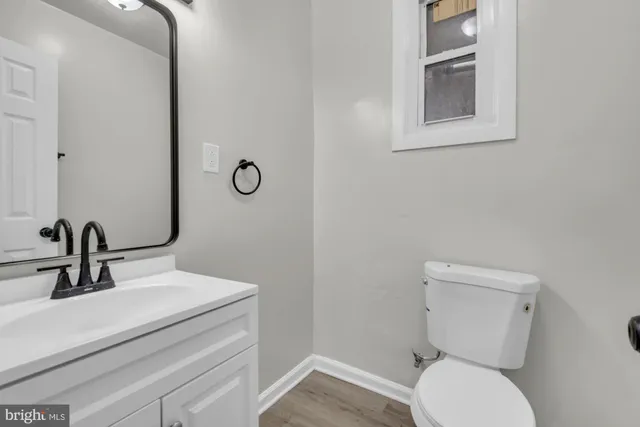 a bathroom with a toilet sink and mirror
