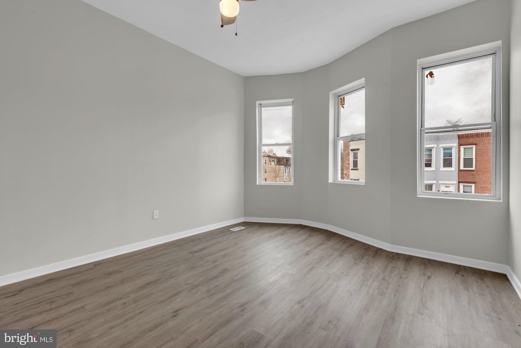 1904 Kennedy Avenue Baltimore, MD 21218 - Photo 16 of 29 an empty room with wooden floor and windows