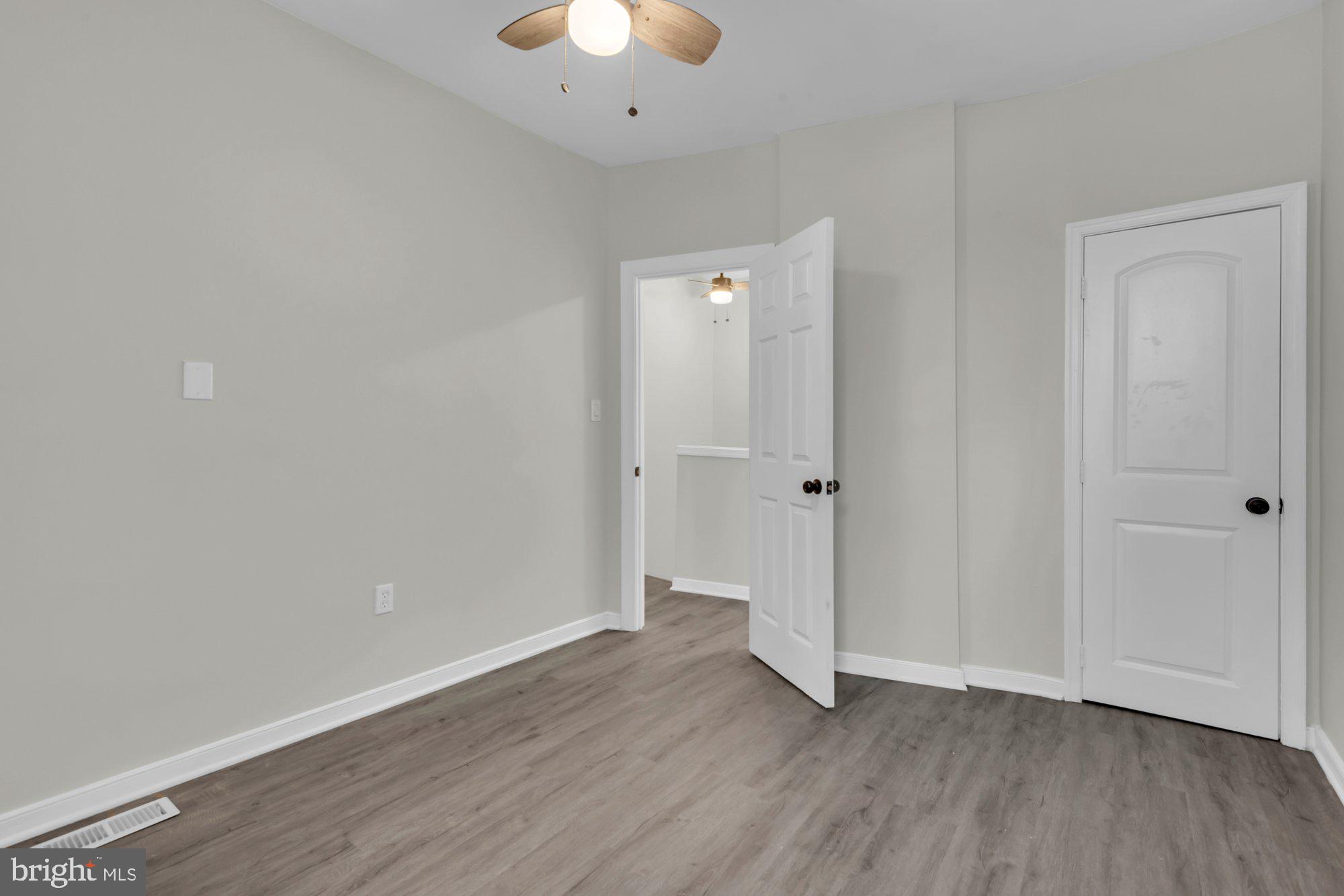 1904 Kennedy Avenue Baltimore, MD 21218 - Photo 20 of 29 an empty room with wooden floor and a ceiling fan