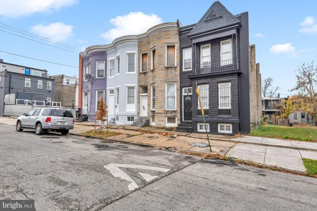 a car parked in front of a white house