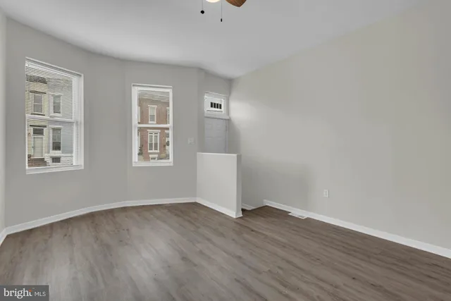 a view of a room with wooden floor and windows