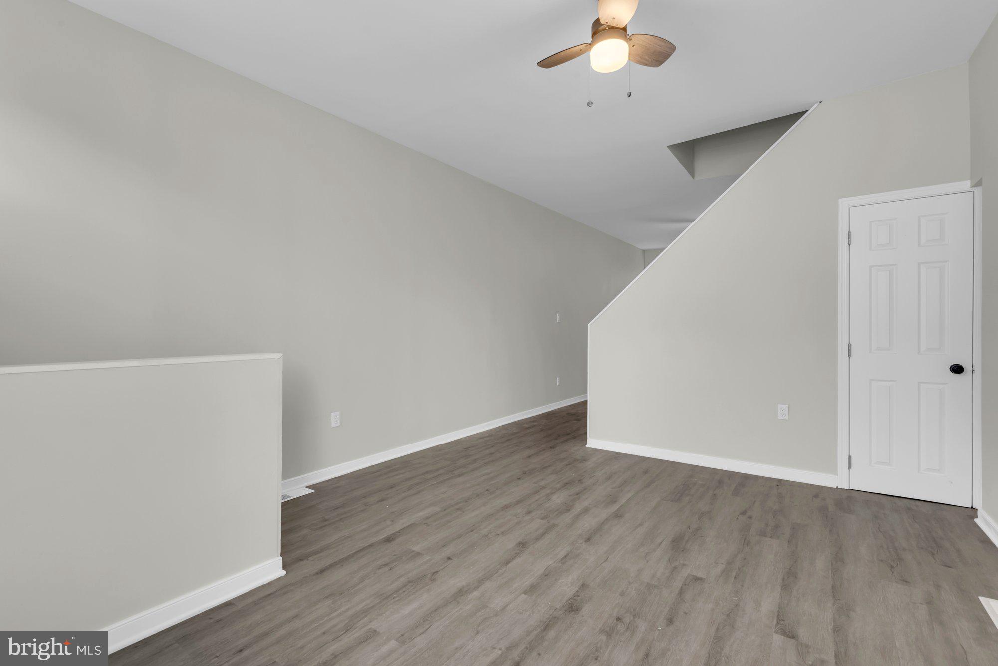 1904 Kennedy Avenue Baltimore, MD 21218 - Photo 7 of 29 an empty room with a chandelier fan and wooden floor