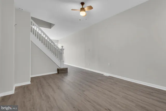 a view of a room with wooden floor and white walls