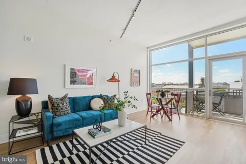 a living room with furniture and floor to ceiling windows