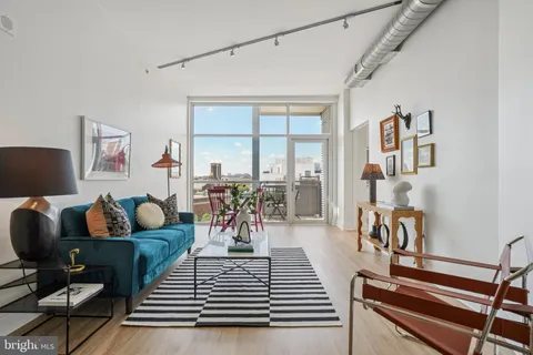 a living room with furniture a rug and a large window