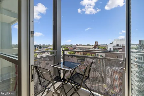 a view of a balcony with furniture and a floor to ceiling window