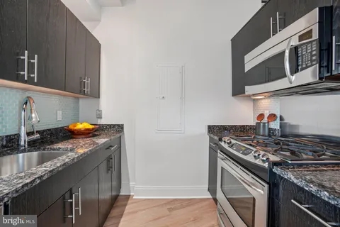 a kitchen with stainless steel appliances granite countertop a sink stove and microwave