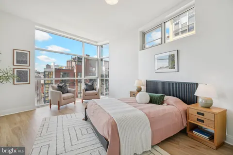 a bedroom with a bed and a large window