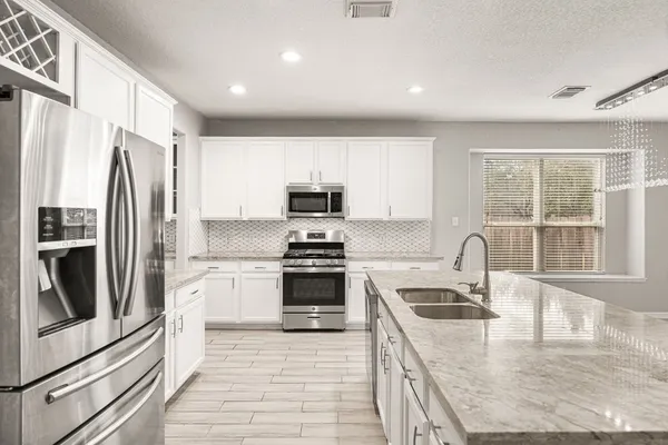 a spacious bathroom with a granite countertop sink a toilet a mirror and shower
