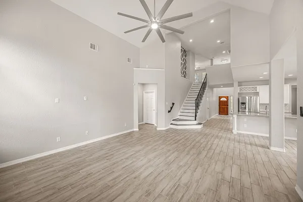 a view of a hallway with wooden floor and windows