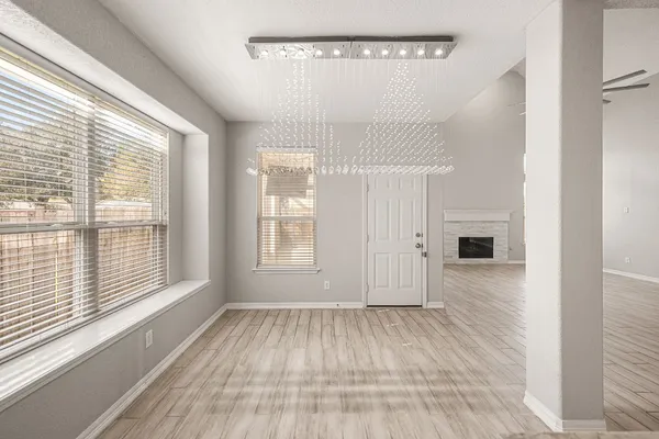 a large white kitchen with kitchen island a stove a sink dishwasher and white cabinets with wooden floor