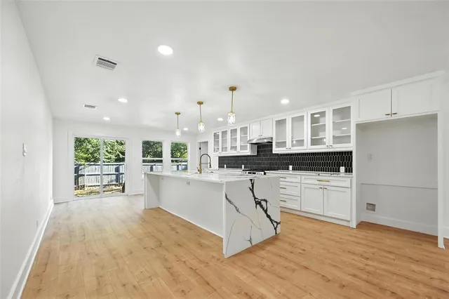 a kitchen with stainless steel appliances kitchen island wooden cabinets and refrigerator