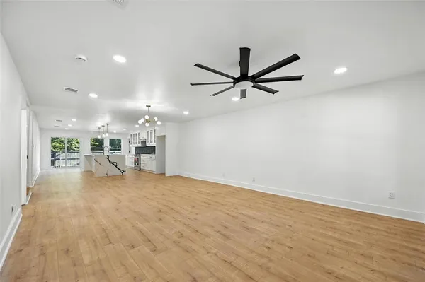 an empty room with kitchen appliances and a ceiling fan