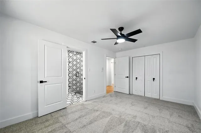 a view of an empty room with a ceiling fan