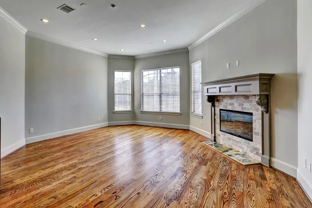 a view of an empty room with a window and fireplace