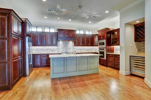 a kitchen with stainless steel appliances granite countertop a refrigerator and a stove
