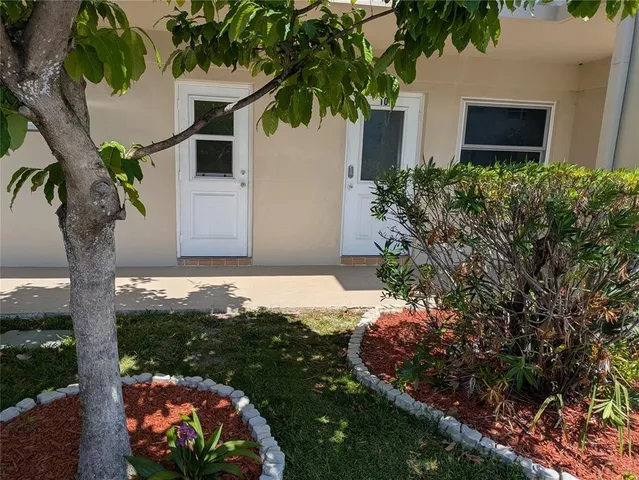 a backyard of a house with a garden and outdoor seating