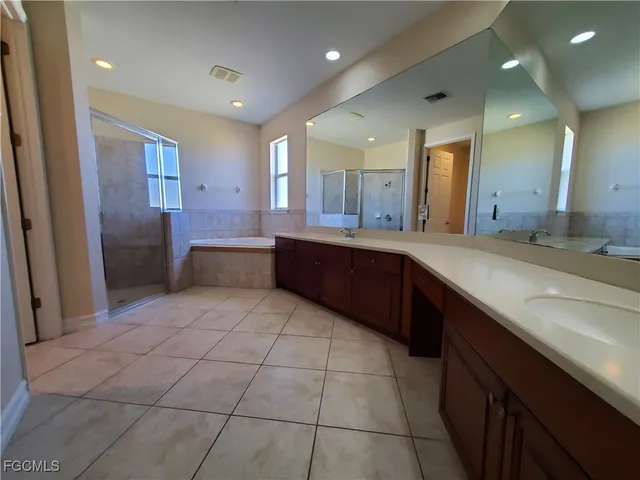 a large bathroom with a large mirror vanity and a sink