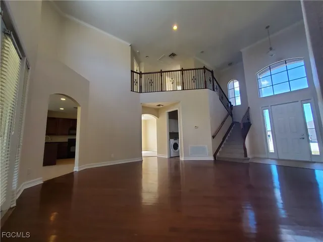 an empty room with wooden floor and entrance