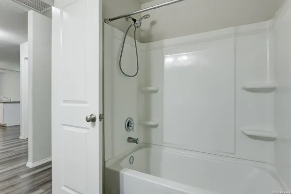 a bathroom with a bath tub with a shower