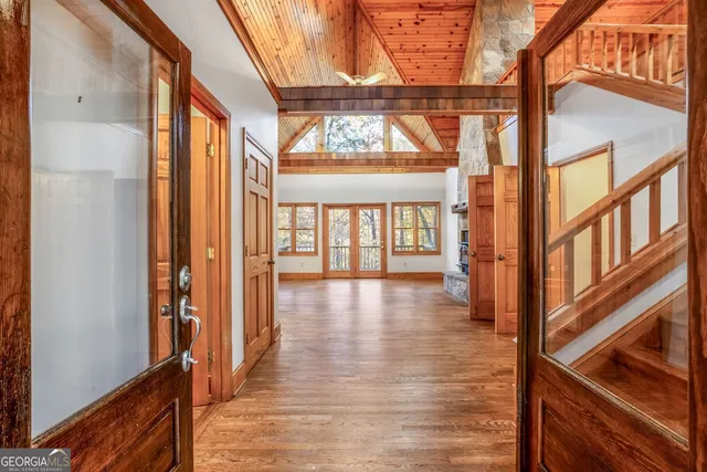 an empty room with wooden floor fireplace and windows