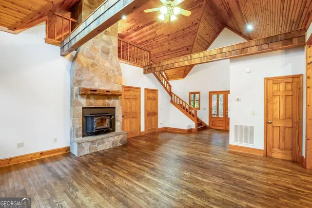 a kitchen with stainless steel appliances kitchen island granite countertop a refrigerator a sink dishwasher a stove and a dining table with wooden floor