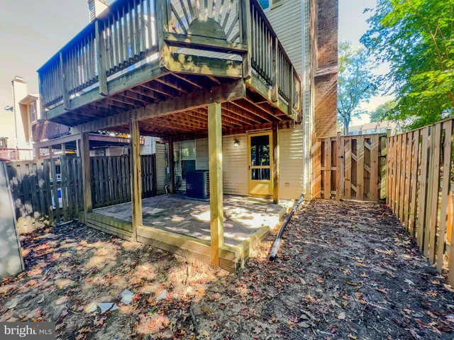 a view of a house with a large tree and wooden fence