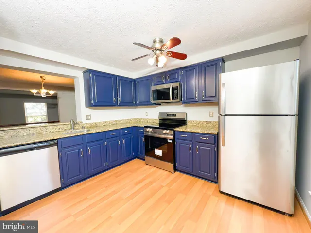 a kitchen with wooden cabinets stainless steel appliances and a window