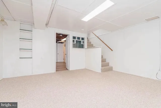 a view of an empty room with closet and windows