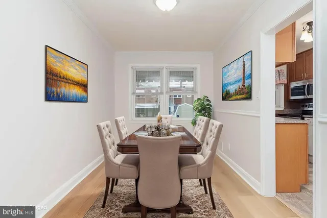 a dining room with furniture a window and wooden floor
