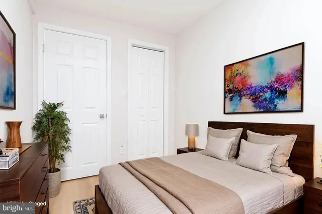 a bedroom with bed and paintings on the wall