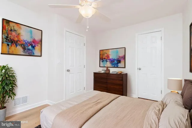 a bedroom with a bed and a painting on the wall