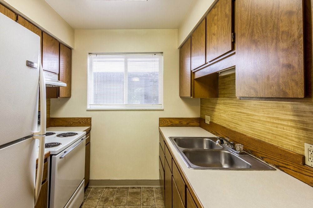 1335 Southwest 2nd Street Pendleton, OR 97801 - Photo 9 of 10 a kitchen with stainless steel appliances granite countertop a sink stove and refrigerator