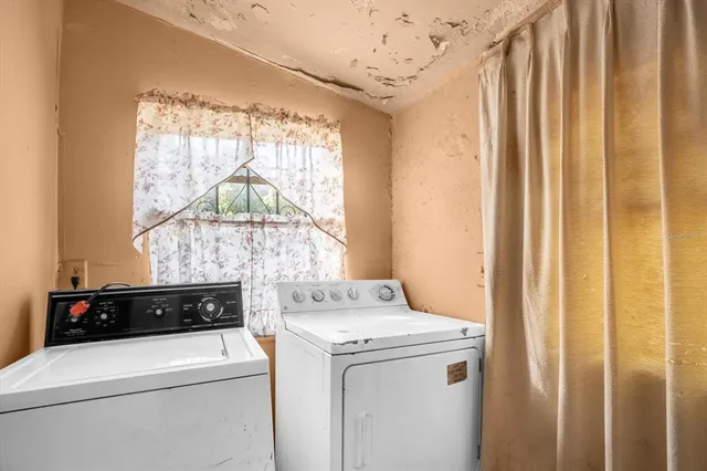 a view of washer and dryer with bathroom in the background