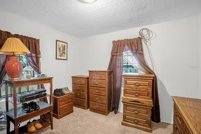 a view of a bedroom with furniture and window