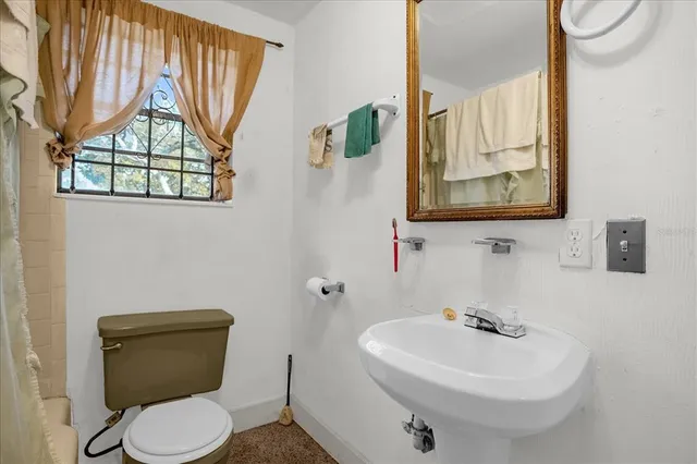 a bathroom with a sink mirror and toilet