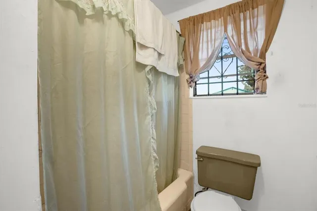a white toilet sitting next to a shower curtain