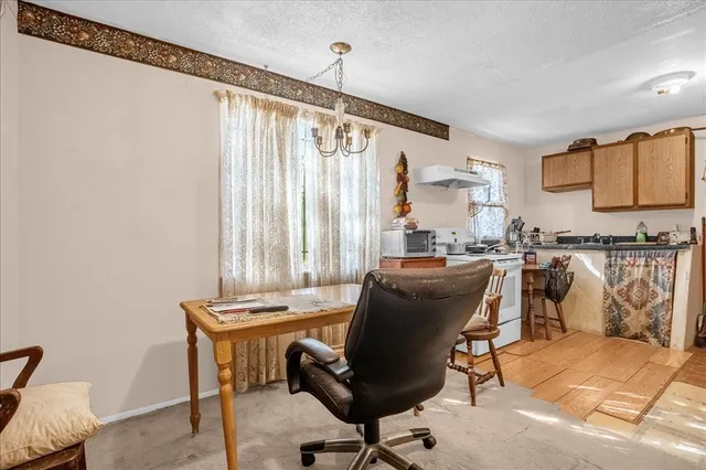 a view of a workspace with furniture and a window